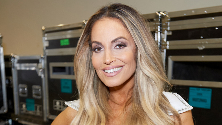 Trish Stratus takes a photo backstage at a WWE event