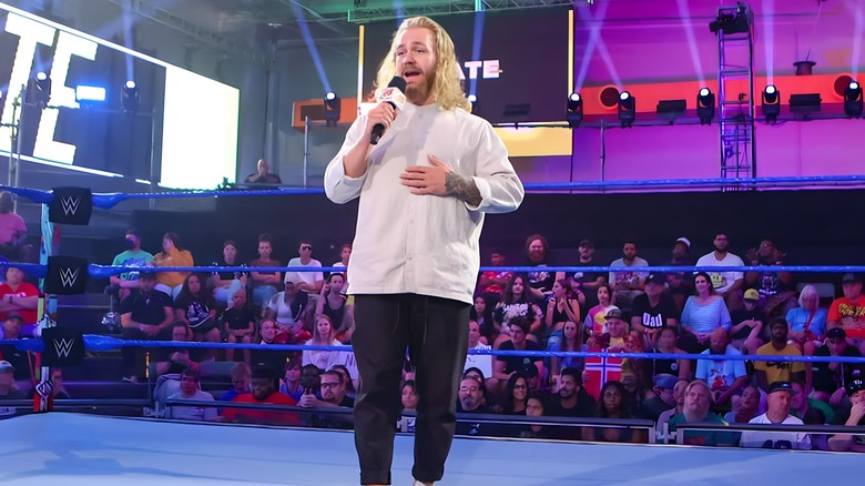 Tyler Bate with microphone in the middle of the ring