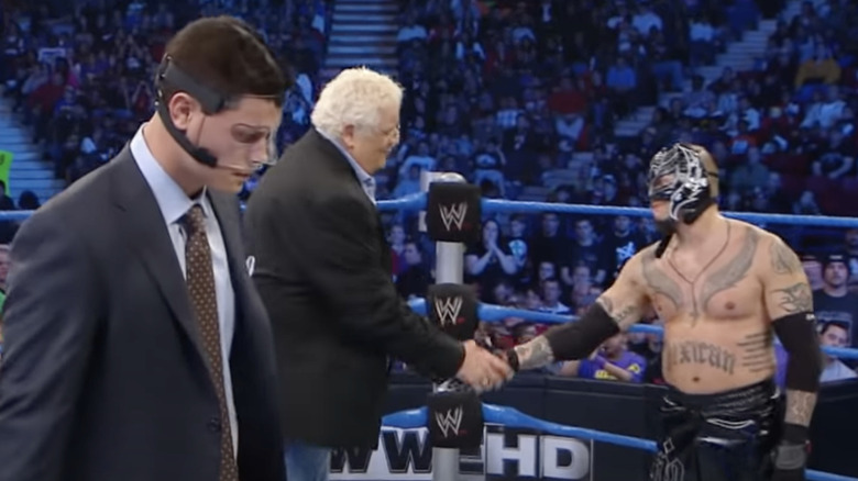 Cody looks at Mysterio shaking Dusty Rhodes's hand