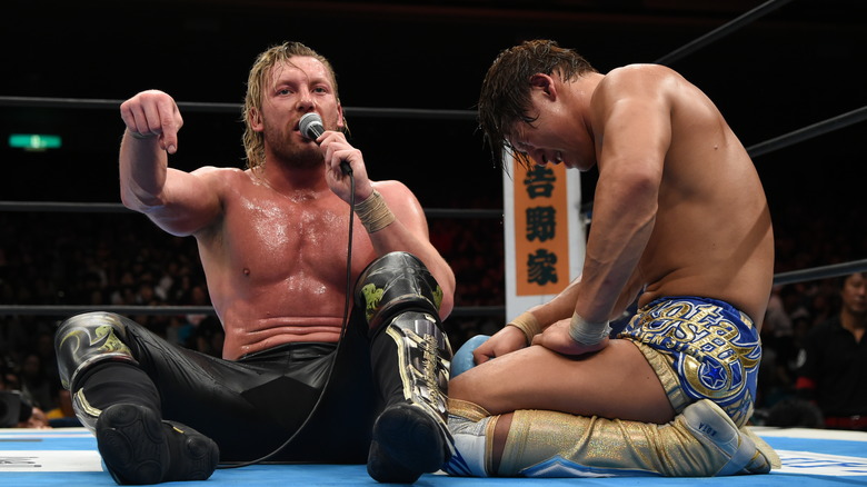 Kenny Omega cuts a promo next to his best pal, Kota Ibushi