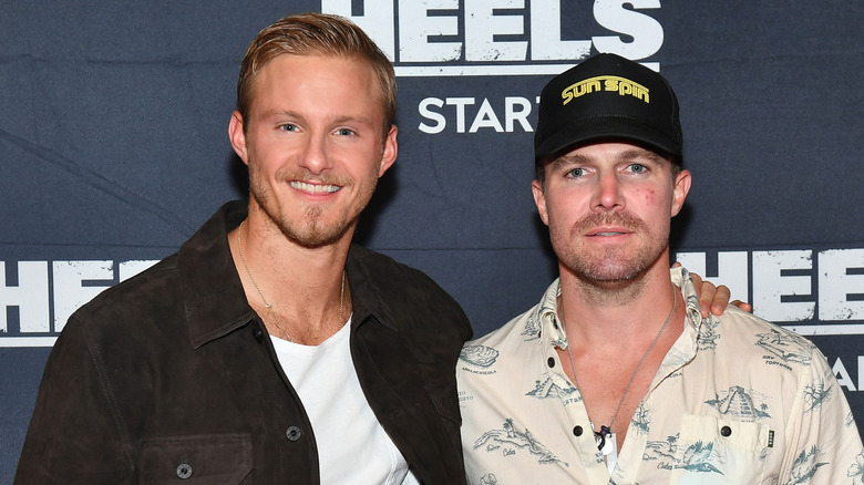 Alexander Ludwig and Stephen Amell posing