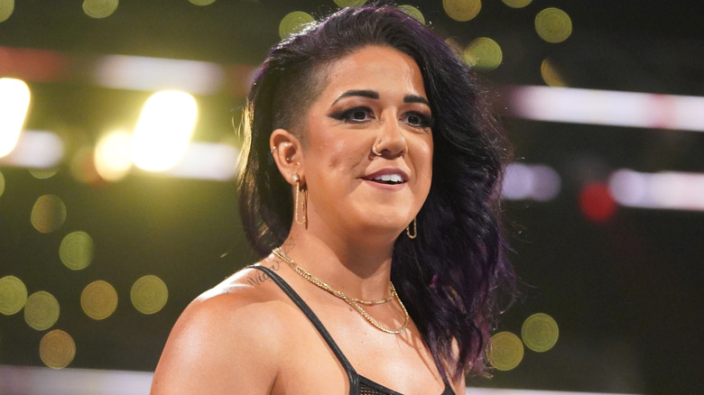 Bayley is wearing gold dangly earrings.