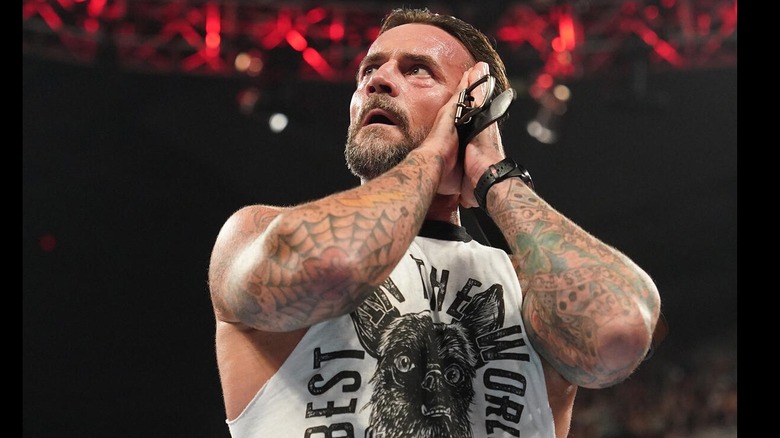 CM Punk gestures for the GTS while sporting a shirt with his dog Larry on it