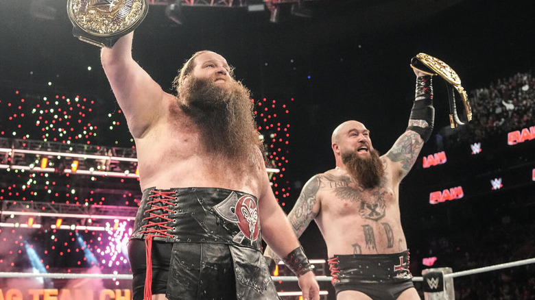 Ivar and Erik hold up the WWE World Tag Team Championships.