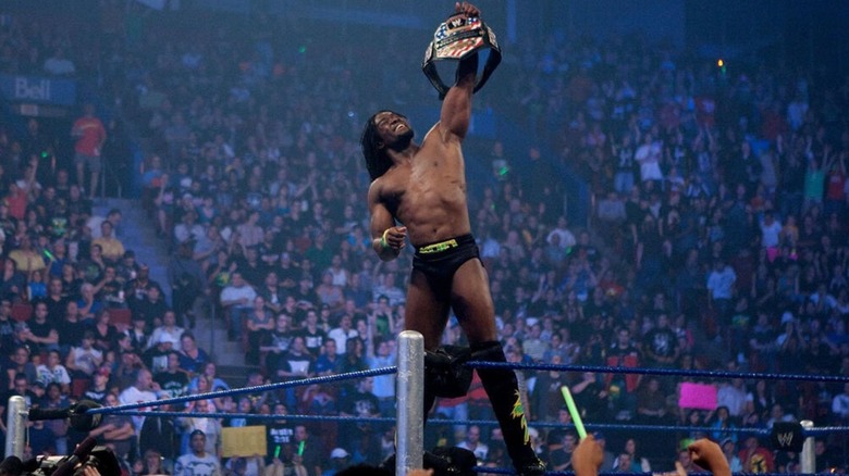 Kofi Kingston celebrates on the turnbuckle, holding up his newly won United States Championship.