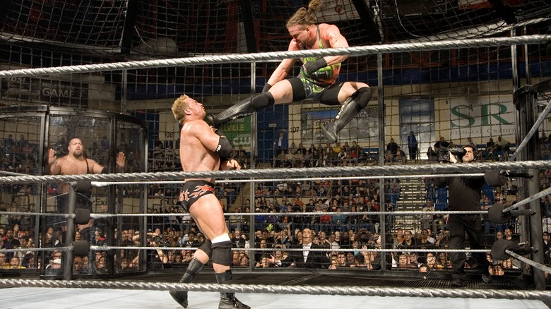 Rob Van Dam dropkicks Test in the throat as The Big Show looks on inside the Extreme Elimination Chamber at WWE ECW December to Dismember