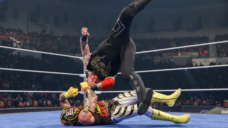 Rey Mysterio, squeezing onto Kevin Owens' wrist as he armdrags him