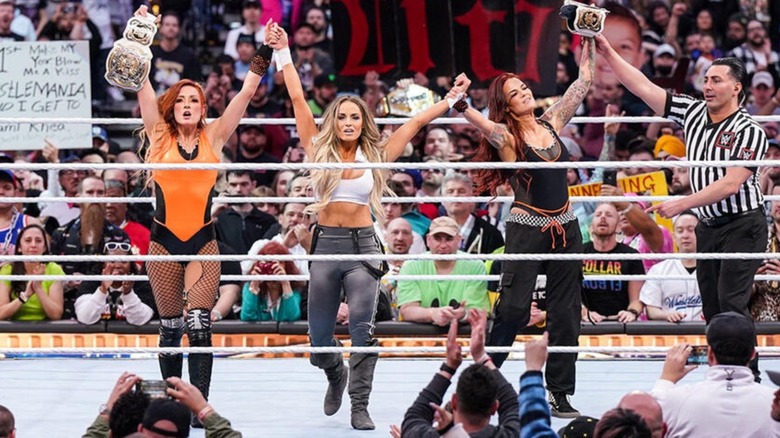 Trish Stratus holds up the hands of Becky Lynch and Lita