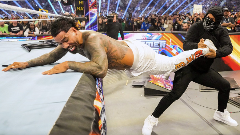 Jimmy Uso pulling Jey Uso out of the ring