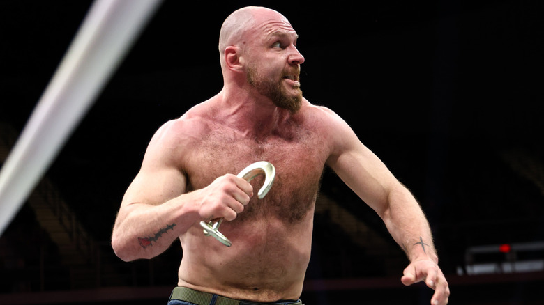 Jon Moxley holding a metal hook