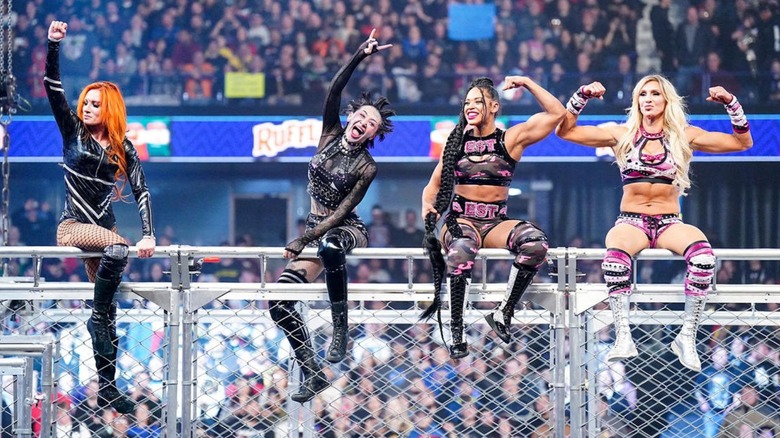 Becky Lynch, Shotzi, Bianca Belair, and Charlotte Flair sit atop the WarGames cage following their win at Survivor Series.