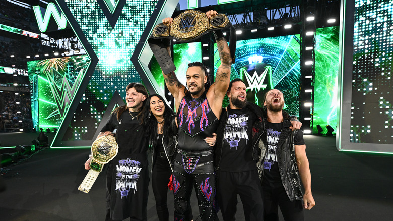 Damian Priest holds up the World Heavyweight Championship on the stage alongside the rest of the Judgment Day at WrestleMania 40.