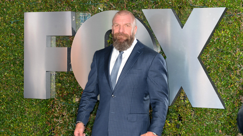 Paul "Triple H" Levesque stands on the red carpet in front of a "FOX" logo.