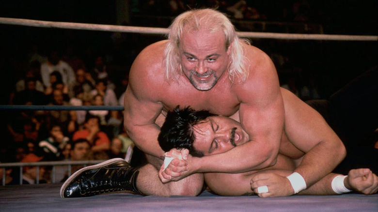 Kevin Sullivan smiles as he cinches in a headlock