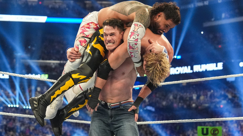 John Cena hoisting both Jey Uso and Logan Paul onto his back during the 2025 Royal Rumble