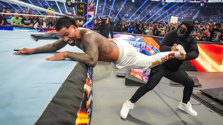 Jimmy Uso pulling Jey Uso out of the ring