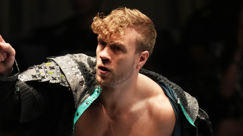 Will Ospreay stands on the top rope