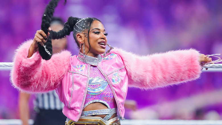 Bianca Belair poses on the ring apron