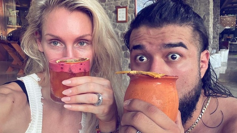 Charlotte Flair and Andrade El Idolo hold drinks