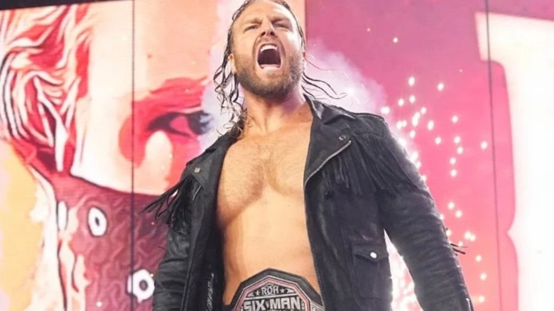 "Hangman" Adam Page heads down to the ring for a match, wearing his ROH Six Man Tag Team Championship around his waist, on an episode of AEW programming.