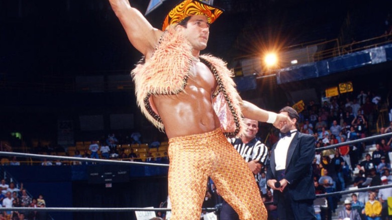 Disco Inferno dances and poses in the middle of the ring, wearing a cowboy hat, in the middle of the ring before a match on WCW programming.