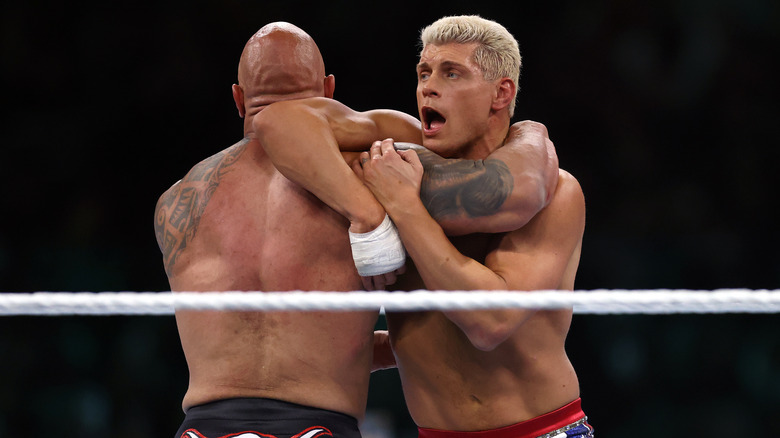 The Rock and Cody Rhodes grappling in the ring