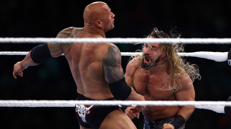 The Rock and Seth Rollins exchanging blows