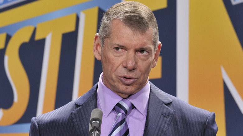 Vince McMahon standing at a mic