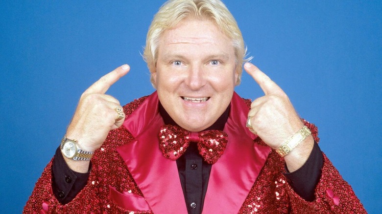 Bobby "The Brain" Heenan points to his brain, while dressed in costume, during a backstage photoshoot in WWE.