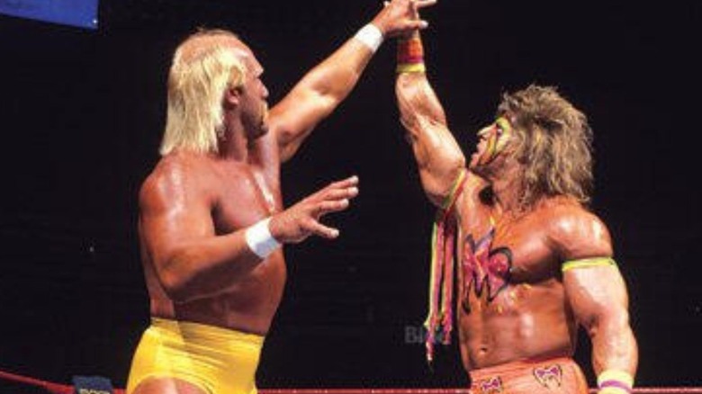 Hulk Hogan and the Ultimate Warrior size each other up in the ring during a WrestleMania match.