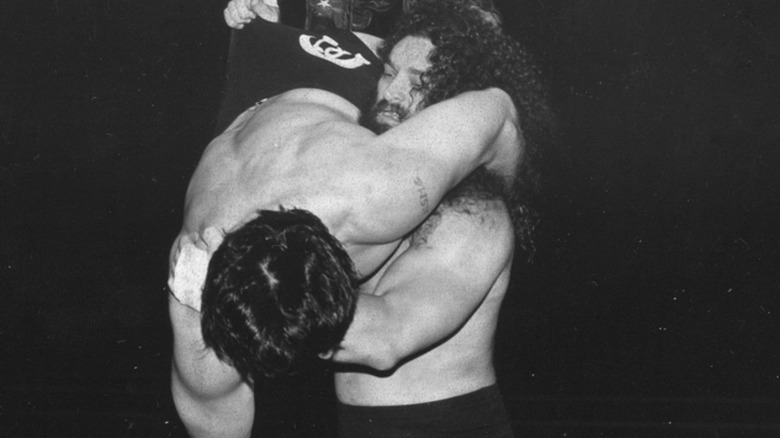 Bruiser Brody slams an opponent in the ring.