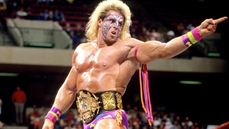 Ultimate Warrior poses in the ring before a match wearing the WWF championship.