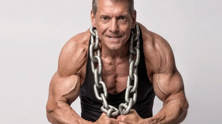 Vince McMahon flexes and poses with a chain around his next for an edition of Muscle & Fitness.