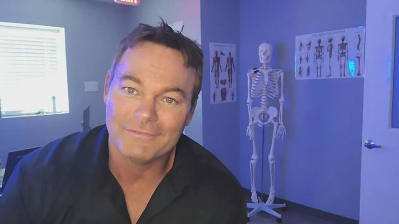 Shawn Stasiak in front of skeleton