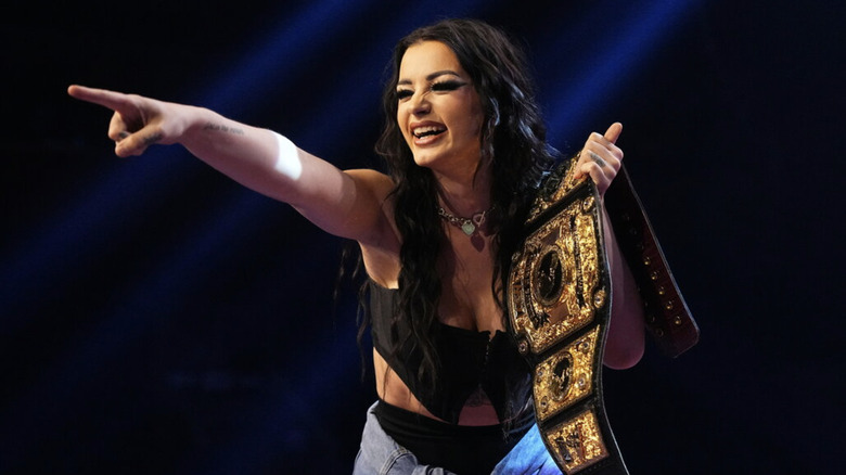 Saraya holding the AEW Women's title and pointing her finger