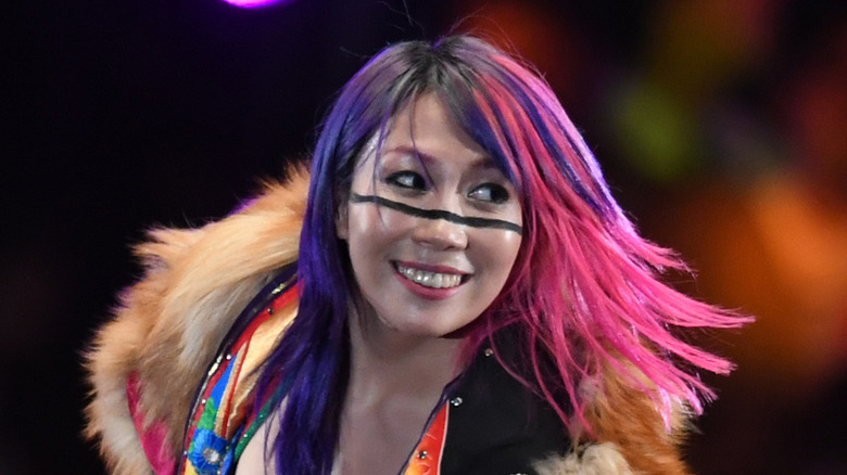 Asuka smiling in fur lined outfit