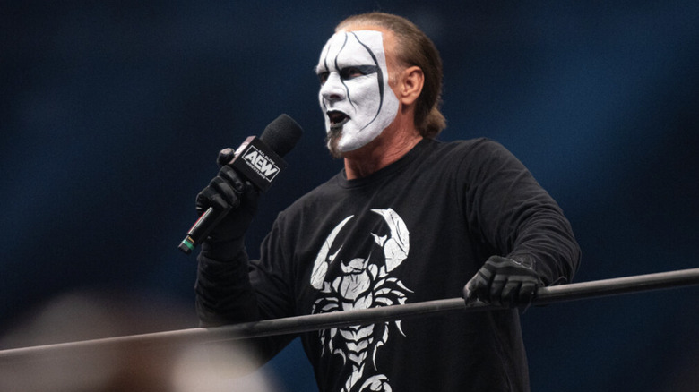 Sting speaking into an AEW branded microphone in the ring