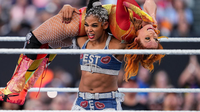 Bianca Belair with Becky Lynch on her shoulders