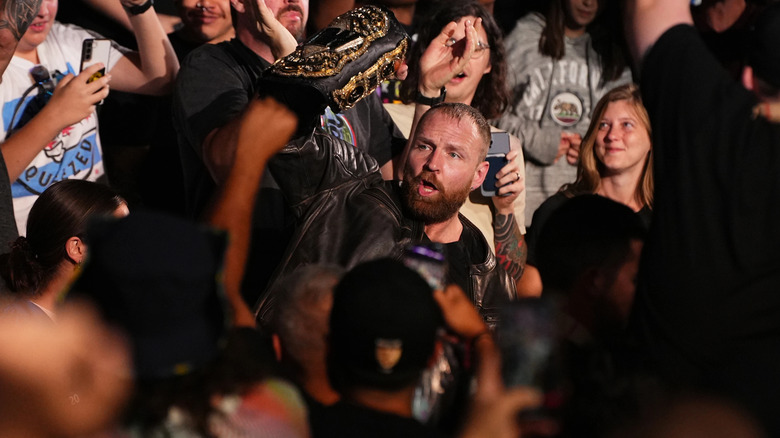 Jon Moxley holds up his title in the crowd