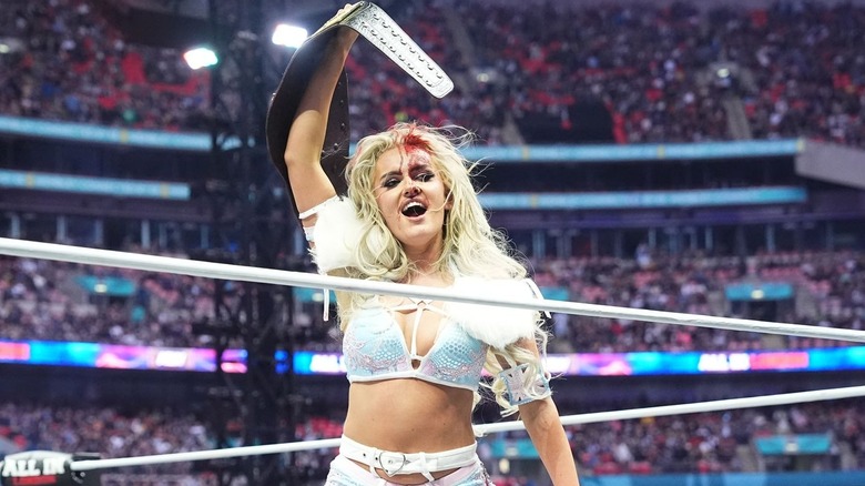 A bloody Mariah May raises her newly-won title belt at AEW All In