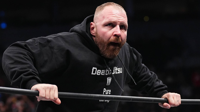 Jon Moxley leans over top rope wearing Blackpool Combat Club hoodie