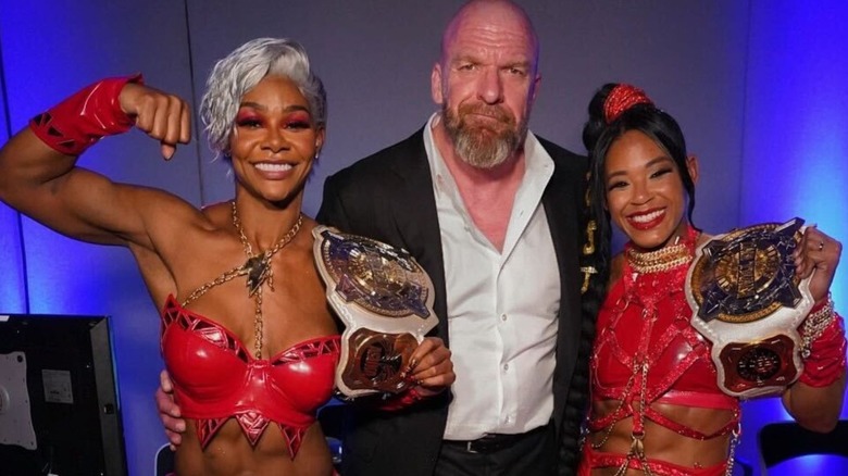 Paul "Triple H" Levesque poses with new Women's Tag Team Champions Jade Cargill and Bianca Belair backstage after their title win at Backlash.
