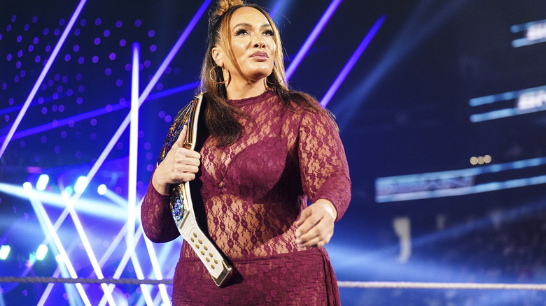 Nia Jax holding her title on her shoulder