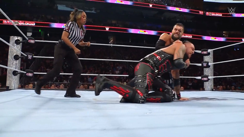 Balor wearing Priest down with a submission