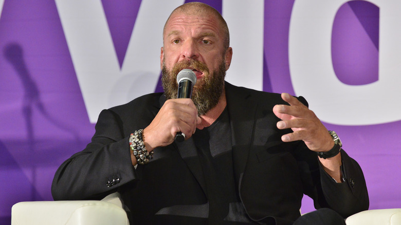 Triple H speaking into a microphone at a convention