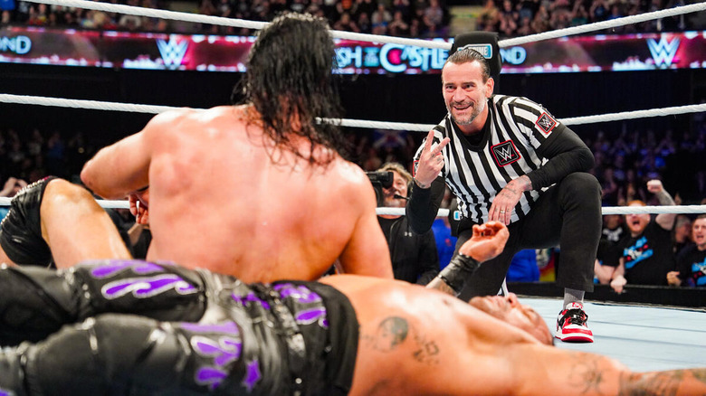 CM Punk signals a two count in front of Drew McIntyre