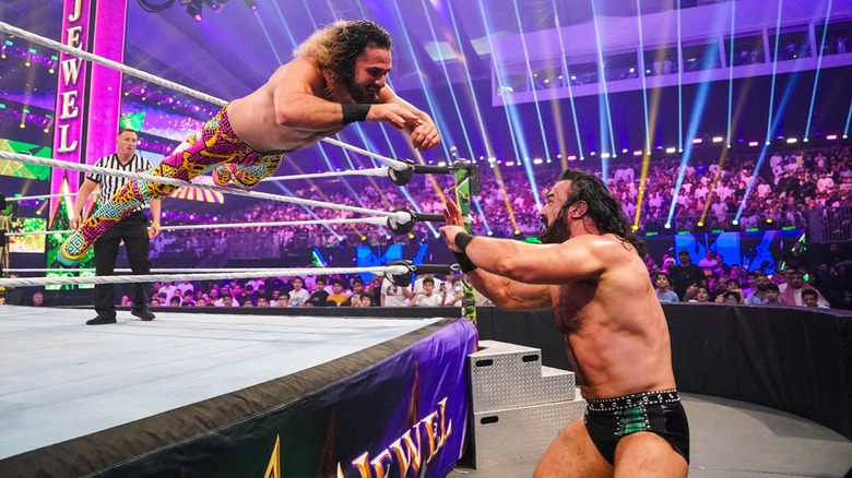 Seth Rollins dives on Drew McIntyre outside the ring