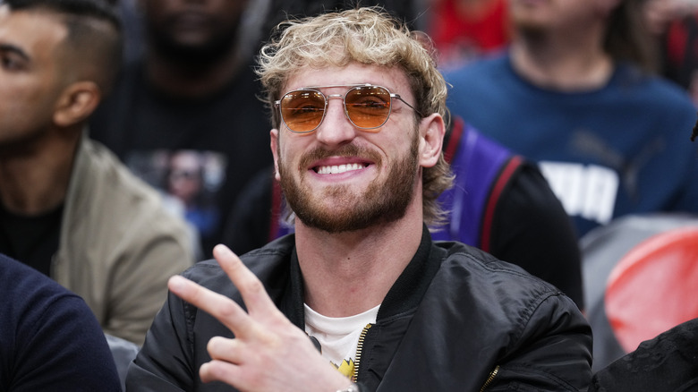 Logan Paul smiling, giving the peace sign