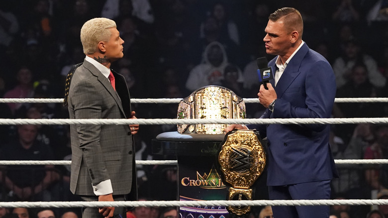 GUNTHER talking into microphone while standing across from Cody Rhodes.