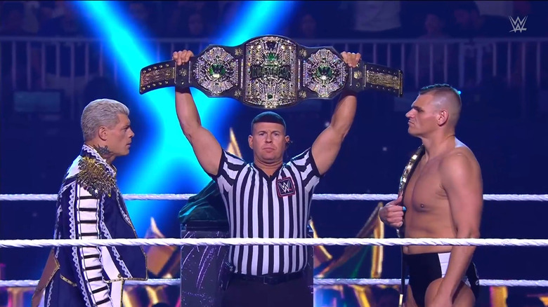 Rhodes and GUNTHER staring each other down as the referee holds up the Men's Crown Jewel Championship